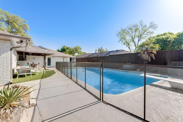 view of pool with a diving board and a patio area