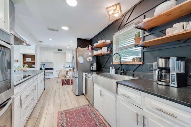 kitchen featuring sink, light hardwood / wood-style flooring, backsplash, stainless steel appliances, and white cabinets