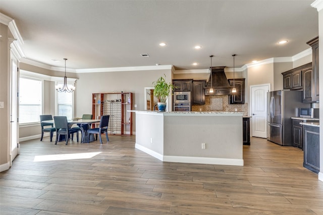 kitchen featuring dark brown cabinets, a kitchen island, custom range hood, and appliances with stainless steel finishes