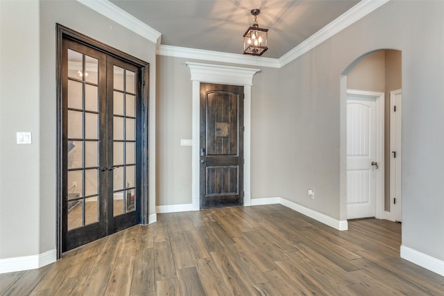 foyer entrance featuring french doors, ornamental molding, and wood-type flooring