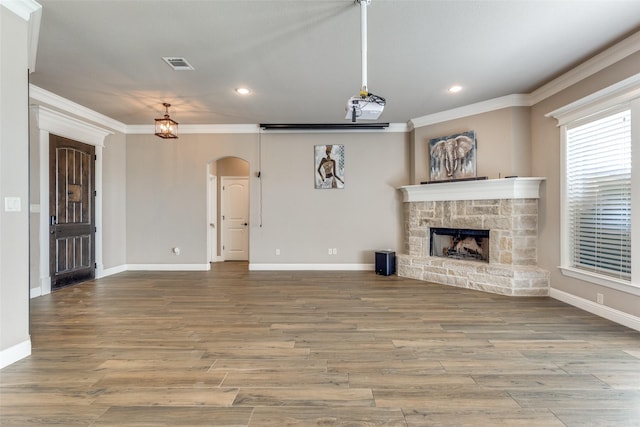 unfurnished living room with hardwood / wood-style flooring, a fireplace, and crown molding