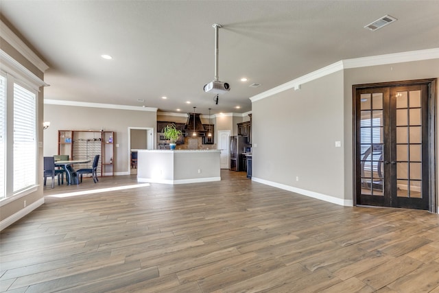 unfurnished living room with light hardwood / wood-style floors, a wealth of natural light, and french doors