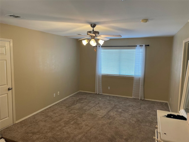 unfurnished room with dark carpet and ceiling fan