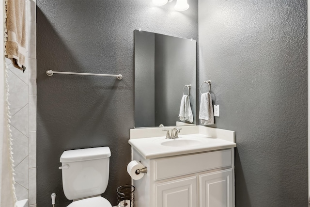 bathroom with toilet, walk in shower, and vanity