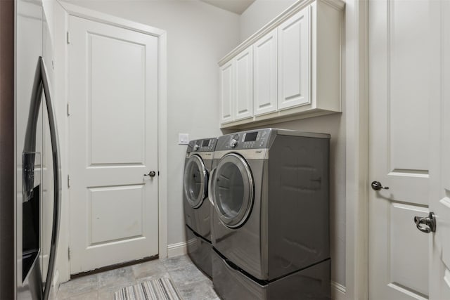 laundry area with washing machine and dryer and cabinets