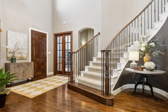 entrance foyer featuring a high ceiling, hardwood / wood-style floors, and french doors