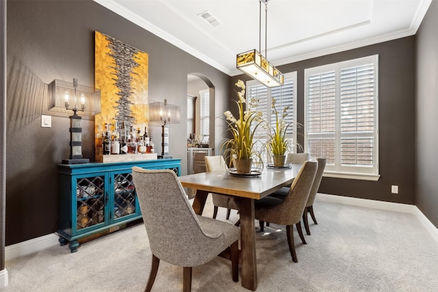 carpeted dining room with crown molding and bar