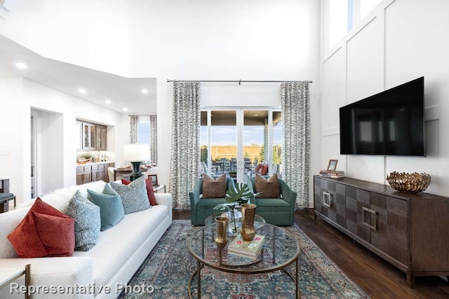 living room featuring dark wood-type flooring and a towering ceiling