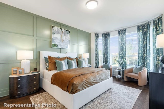 bedroom with dark hardwood / wood-style flooring and multiple windows