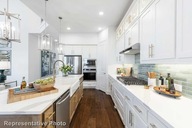 kitchen with light stone counters, sink, white cabinets, and stainless steel appliances