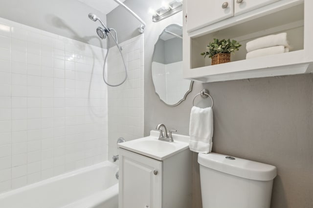 full bathroom featuring vanity, tiled shower / bath, and toilet