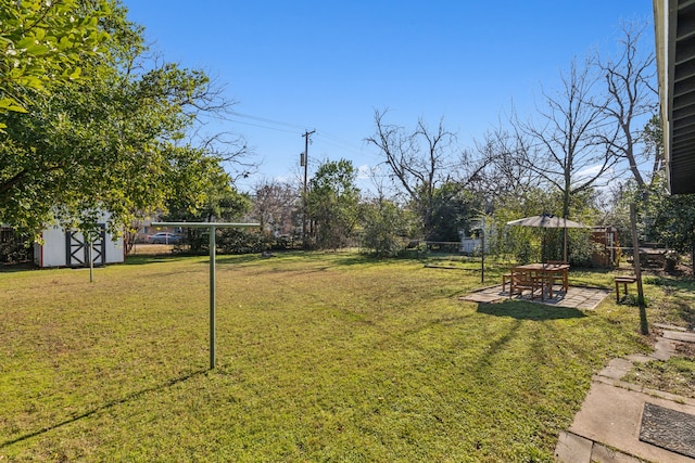 view of yard featuring a storage unit and a patio