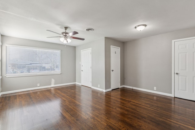 empty room with dark wood-type flooring and ceiling fan