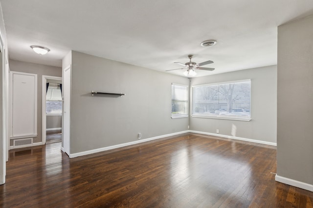 empty room featuring dark wood-type flooring and ceiling fan