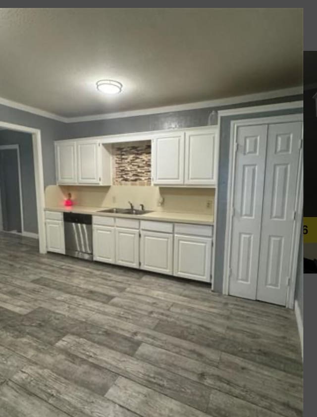 kitchen featuring white cabinets, stainless steel dishwasher, and sink