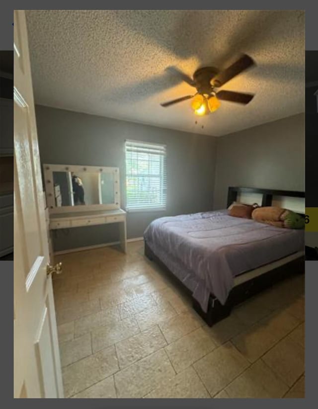 bedroom with ceiling fan and a textured ceiling