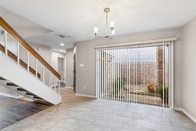 interior space featuring an inviting chandelier and a textured ceiling