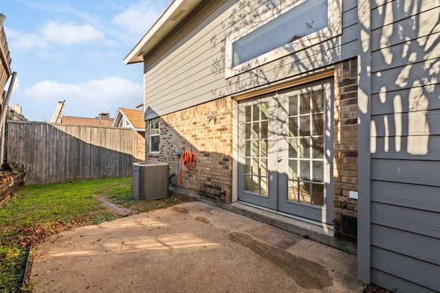 view of exterior entry with central air condition unit, a patio area, and french doors