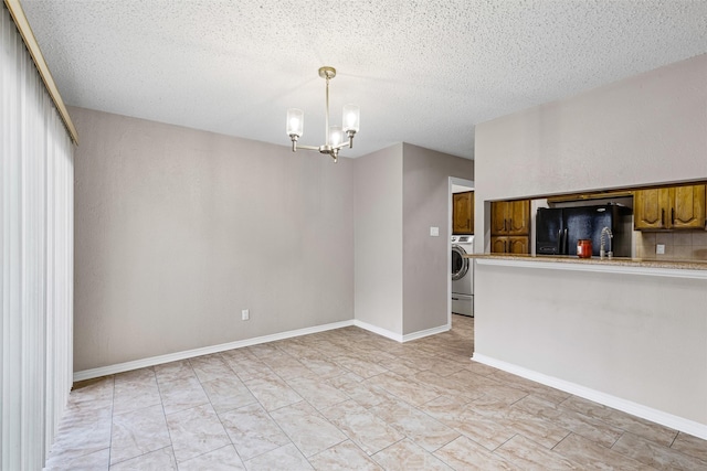 interior space with washer / dryer, a textured ceiling, and a notable chandelier