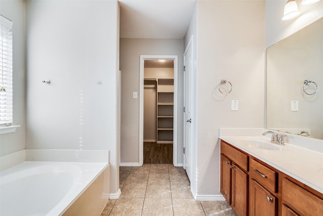 bathroom with tile patterned floors, a bathtub, and vanity