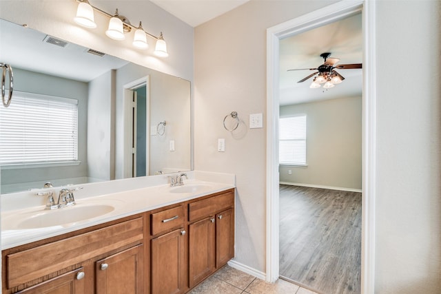 bathroom with tile patterned floors, ceiling fan, vanity, and a bath