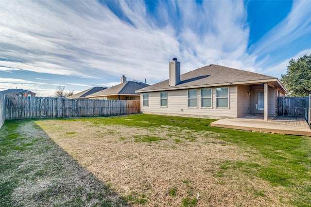 back of house featuring a lawn and a deck