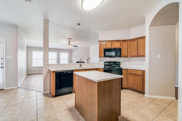 kitchen with kitchen peninsula, sink, black appliances, light tile patterned floors, and a kitchen island