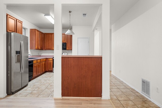 kitchen featuring sink, decorative light fixtures, light tile patterned floors, and black appliances