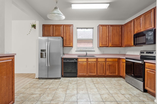 kitchen with light tile patterned flooring, sink, pendant lighting, and black appliances