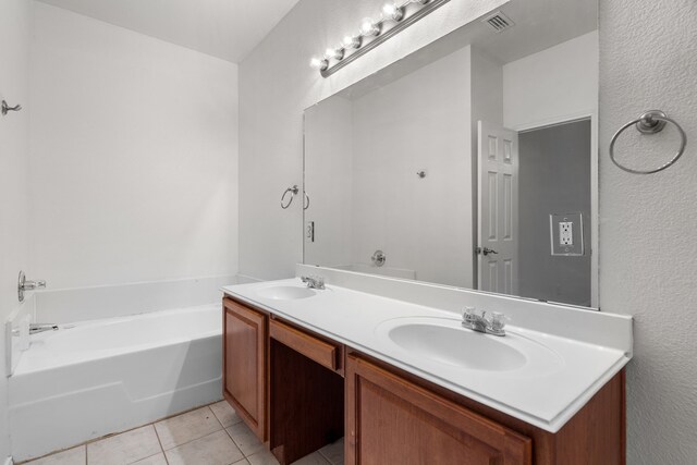 bathroom with tile patterned flooring, vanity, and a tub