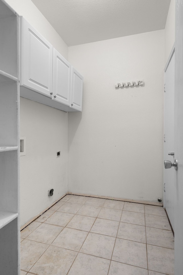 laundry room featuring cabinets, hookup for an electric dryer, and light tile patterned floors