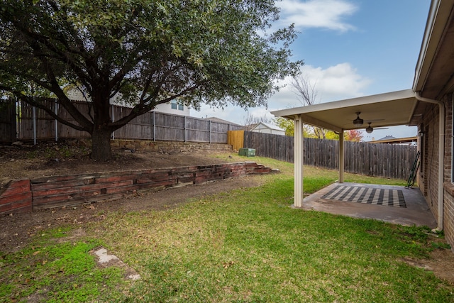 view of yard featuring ceiling fan and a patio