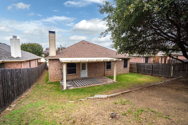 rear view of property featuring a lawn and a patio area