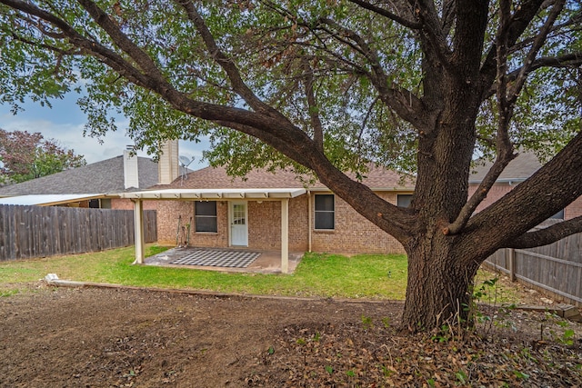 rear view of property with a yard and a patio area