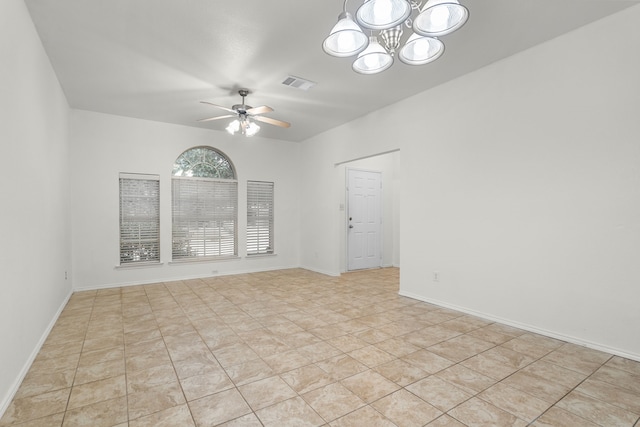 tiled empty room with ceiling fan with notable chandelier