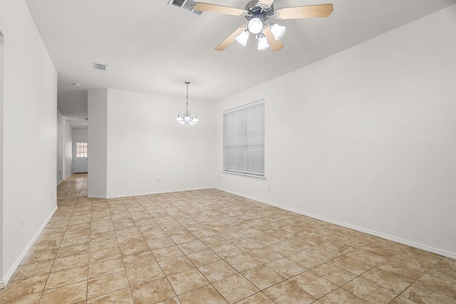 spare room featuring ceiling fan with notable chandelier