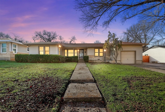 single story home with a lawn and a garage