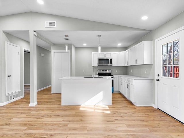 kitchen featuring white cabinets, light hardwood / wood-style floors, decorative light fixtures, and appliances with stainless steel finishes