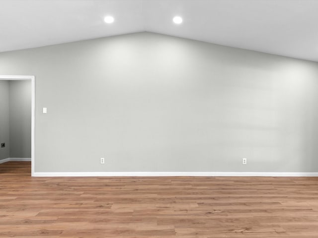 empty room with light hardwood / wood-style floors and lofted ceiling