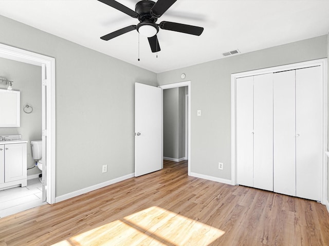 unfurnished bedroom featuring connected bathroom, ceiling fan, a closet, and light hardwood / wood-style flooring