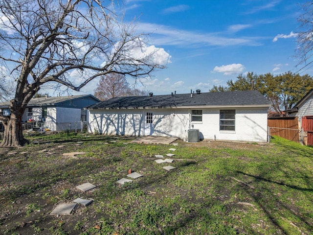 back of house featuring a lawn and central AC