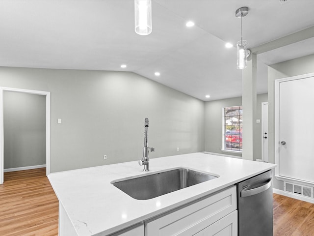 kitchen featuring sink, dishwasher, white cabinetry, hanging light fixtures, and an island with sink