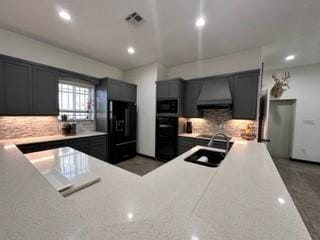 kitchen featuring backsplash, sink, black appliances, and range hood