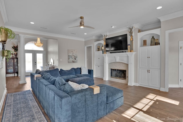 living room with ceiling fan, ornamental molding, wood-type flooring, and ornate columns