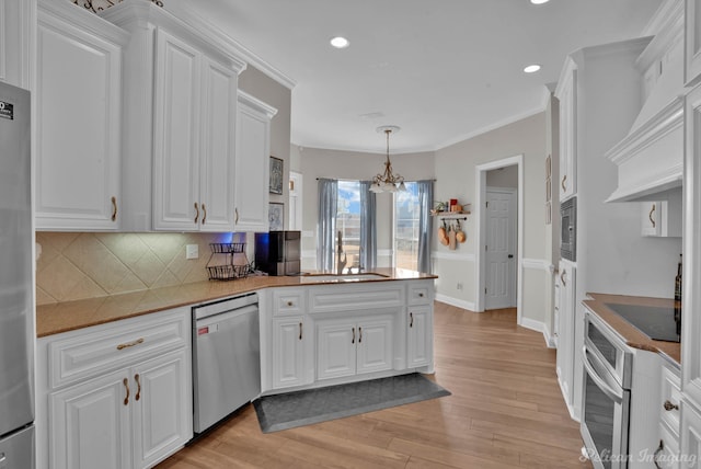 kitchen featuring hanging light fixtures, appliances with stainless steel finishes, sink, and white cabinets