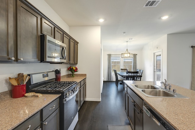 kitchen with dark hardwood / wood-style flooring, dark brown cabinetry, stainless steel appliances, sink, and pendant lighting