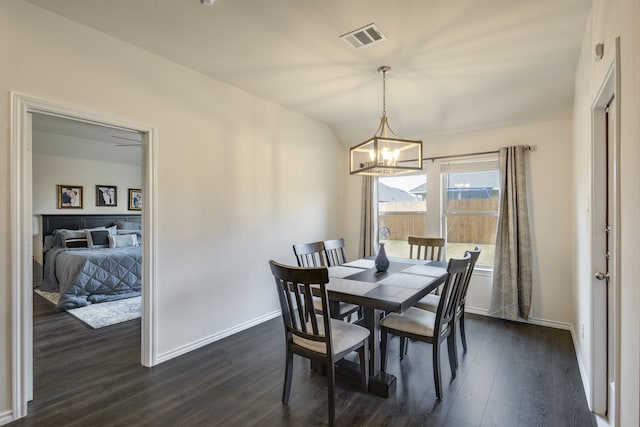 dining area with ceiling fan with notable chandelier and dark wood-type flooring