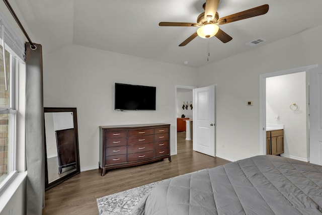 bedroom featuring hardwood / wood-style floors, ceiling fan, lofted ceiling, and ensuite bath