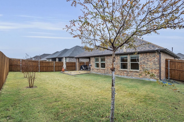 rear view of property featuring a lawn and a patio area