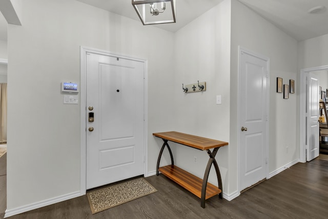 entryway featuring dark wood-type flooring and a notable chandelier